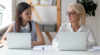 młodsza pracowniczka patrzy na starszą pracowniczkę
